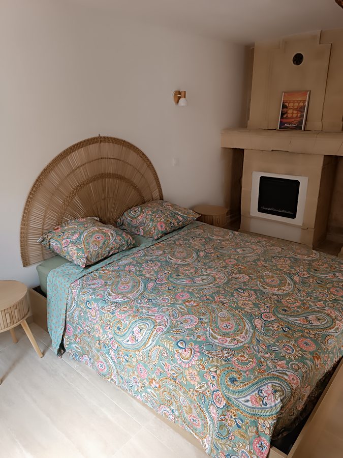 Suite parentale — lit Queen size, tête de lit rotin et cheminée